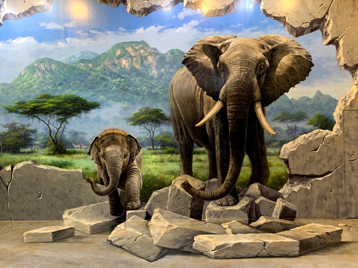 A 3D painting of two elephants coming out from the rocks